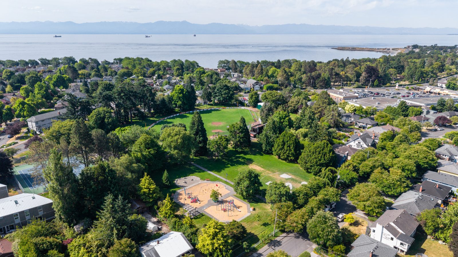 Aerial view of Hollywood Park in Fairfield, Victoria BC, with playground, sports fields and the ocean beyond
